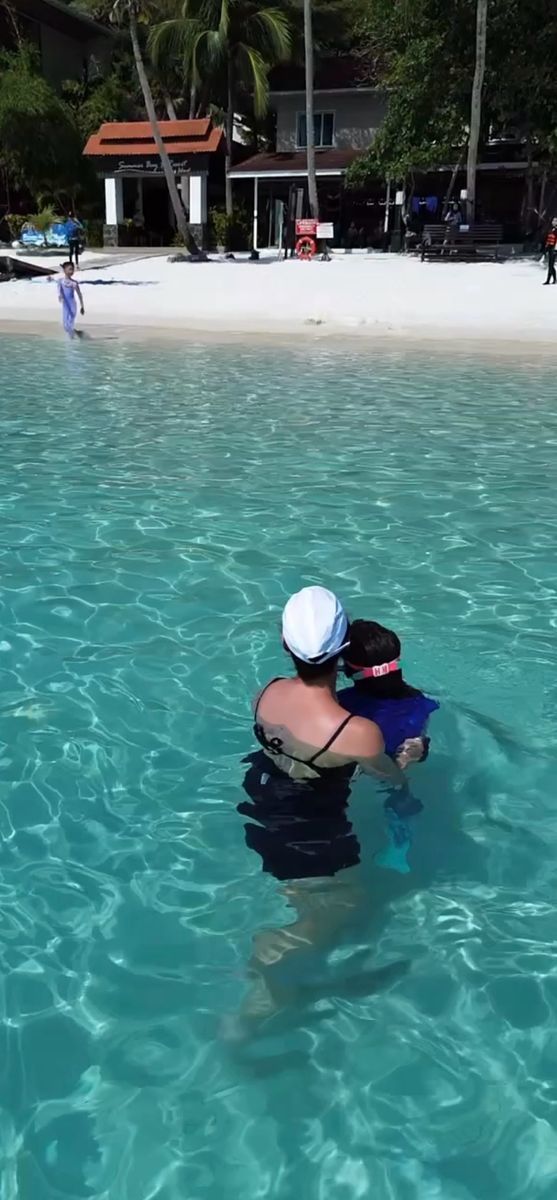 Maman et enfant dans l'eau turquoise